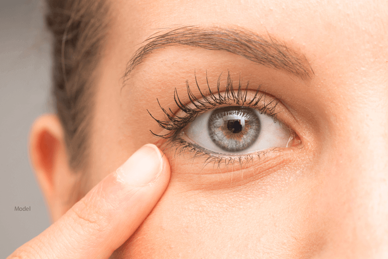 woman pointing at her right eye