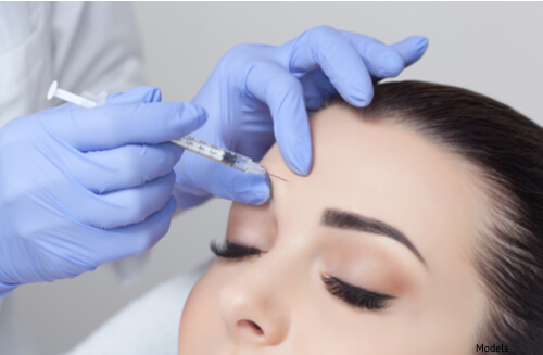 Woman receiving BOTOX® Cosmetic Injections between her eyebrows