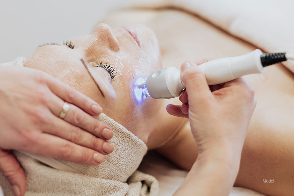 Woman getting laser and ultrasound face treatment in medical spa center